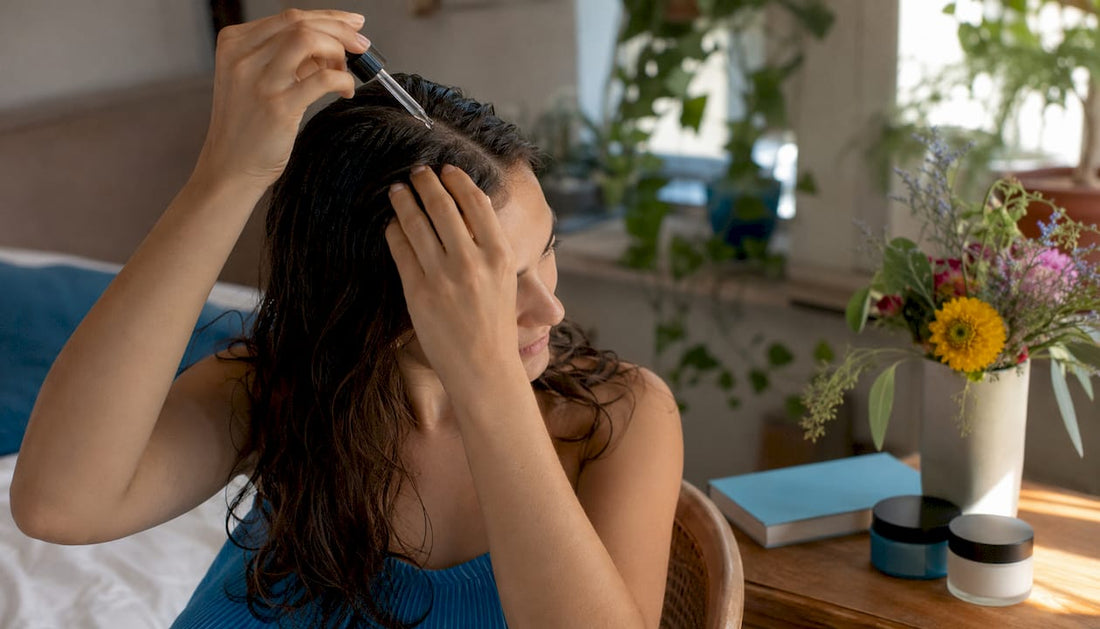 Woman applying hair vitamin serum to scalp